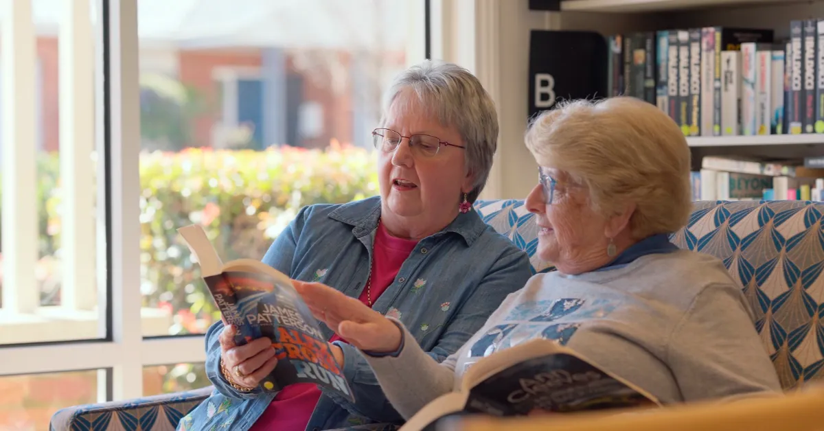 Bedford Heights Estate Retirement Living Residents Reading Book In Library