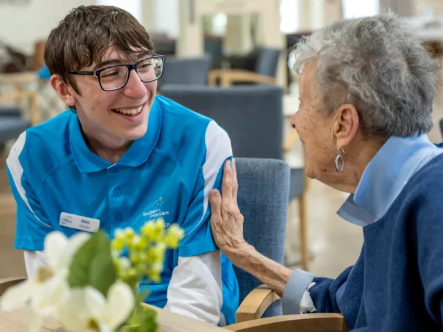 Male Southern Cross Care Cafe Volunteer and Female Resident Chatting Together