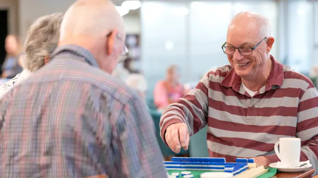 Residents Playing A Board Game Together At The Waterford Retirement Living
