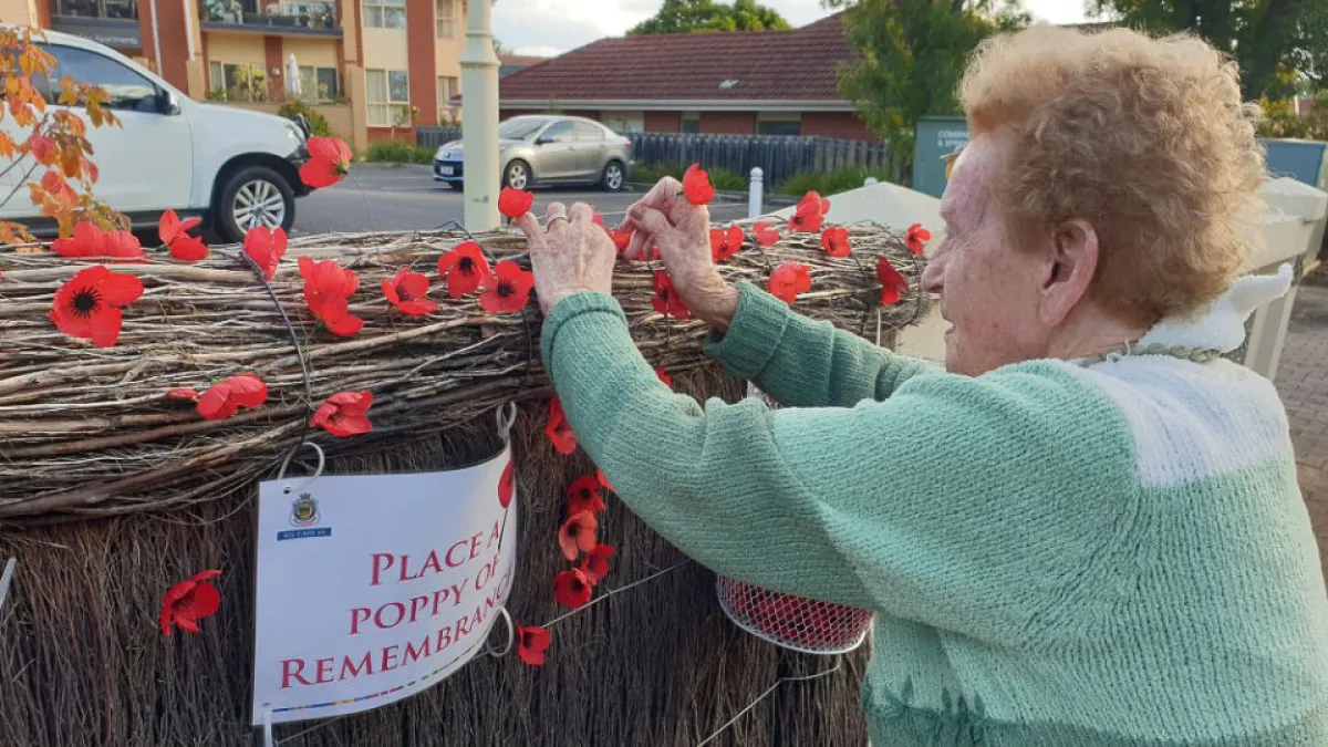 Doreen Read placing a poppy for Anzac Day