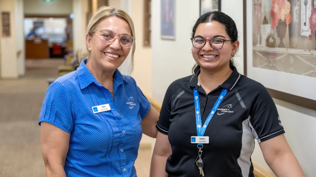 Two staff members standing in a hallway
