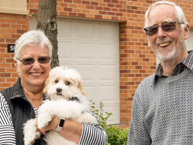 Two happy retirement village residents living their best life with their pet dog.
