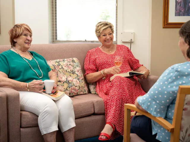Three Female Residents Enjoying Drinks and Socialising At Pine Springs Retirement Village