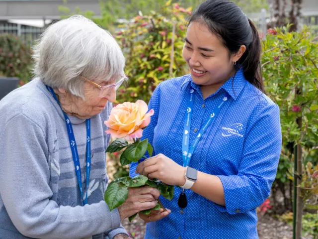 Resident with female support worker in gardens