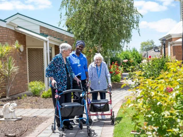 JPII residents with care support worker in garden 