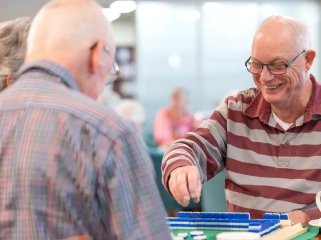 Residents Playing A Board Game Together At The Waterford Retirement Living