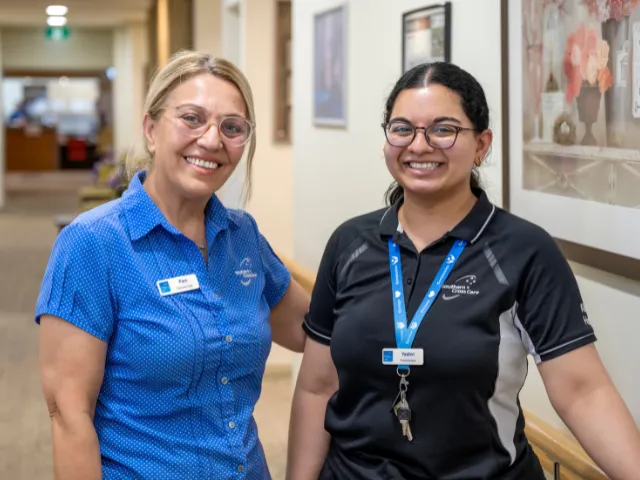 Two staff members standing in a hallway