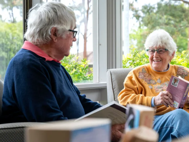 Female & Male Resident Reading Books Together At The Mornington Retirement Village