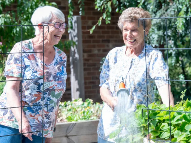 Residents In Community Garden At Pines Close Retirement Living