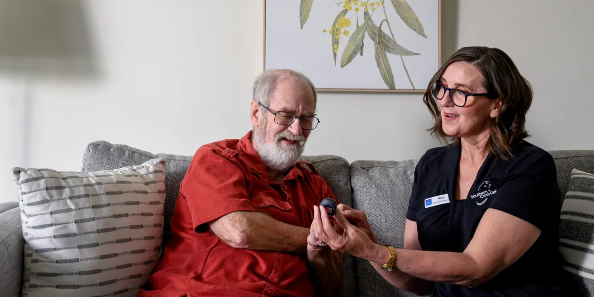 Home Care nurse checking mans blood sugar