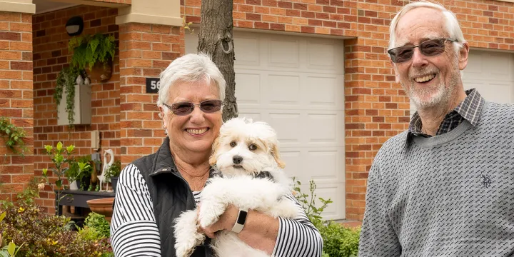 Two happy retirement village residents living their best life with their pet dog.