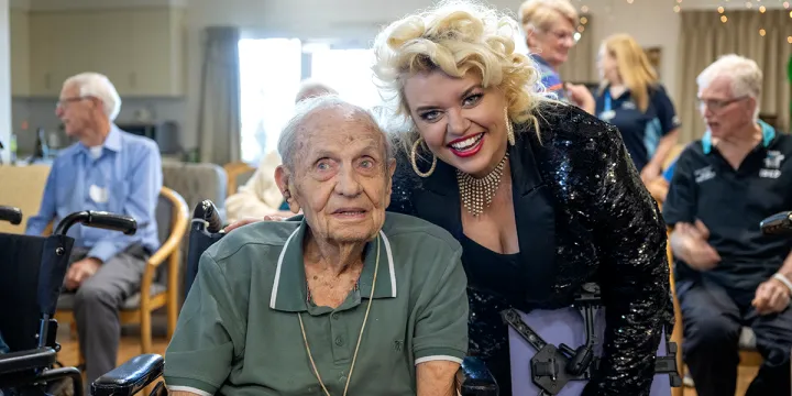 Female Performer and Male Resident Smiling For A Photo