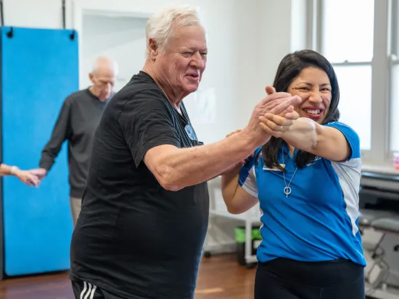Male Health & Fitness Client Dancing With Female Health & Wellness Promoter In Dance Class