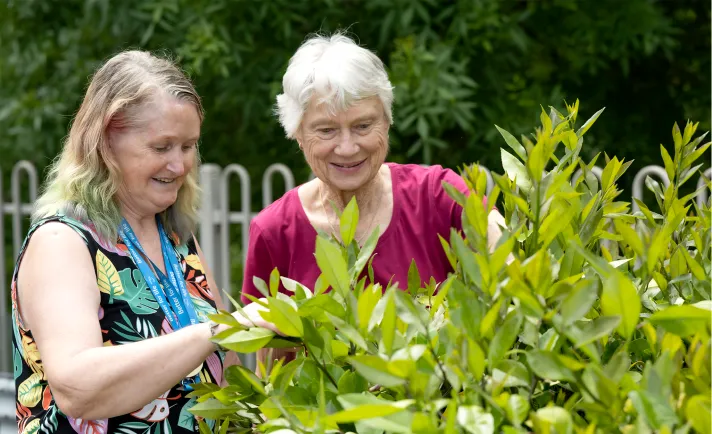 A respite client spends time in the garden interacting with a Southern Cross Care respite assistant