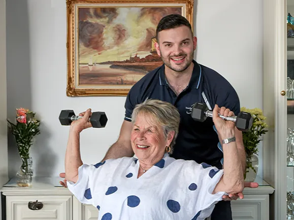 Client Lifting Weights With The Guidance Of Community Transition Care Program Staff Member