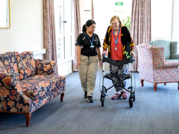 Resident and Staff Member Walking Through Bucklands Residential Care Hallway