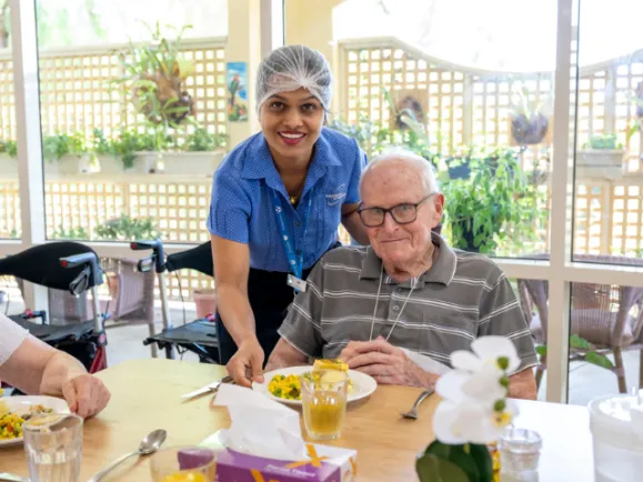 Staff Member Serving Meal To Male Resident At Bucklands Residential Care Dining Room 640x480