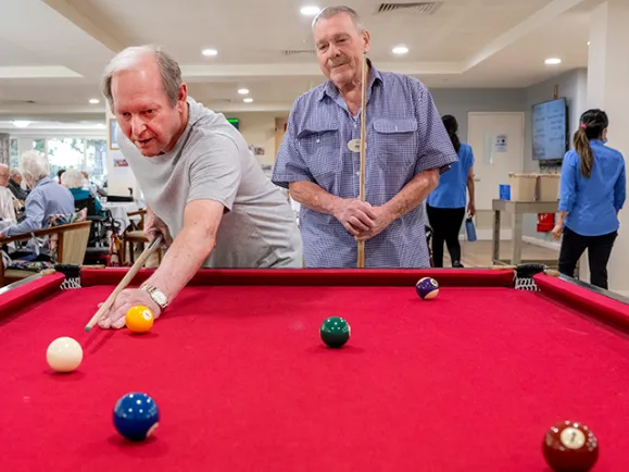Male Residents Playing Billiards Together At The Pines Lodge Residential Care