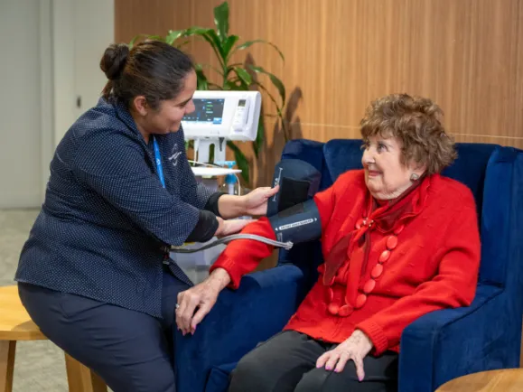 Female Nurse Measuring A Female Resident's Blood Pressure At Carmelite Residential Care