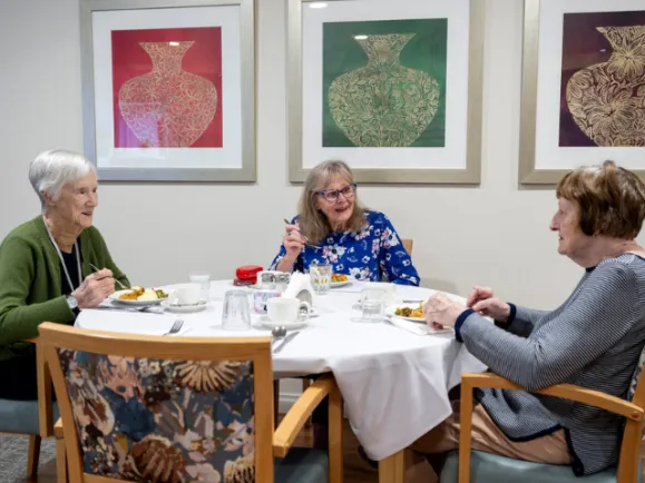 Three Female Resident Eating Their Meal Together In Dining Room At Oaklands Park Lodge Residential Care