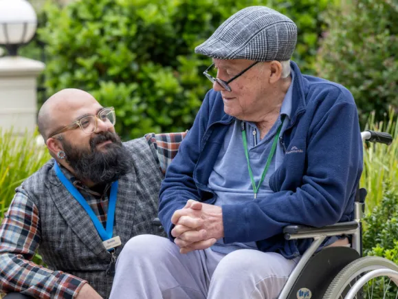 Male Resident and Male Lifestyle Staff Member Having A Chat In The Garden At The Lodge Lourdes Valley Residential Care