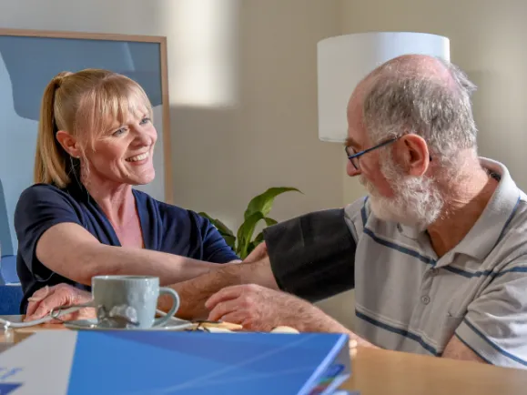 Female Home Care Nurse Taking Blood Pressure Of Male Client.