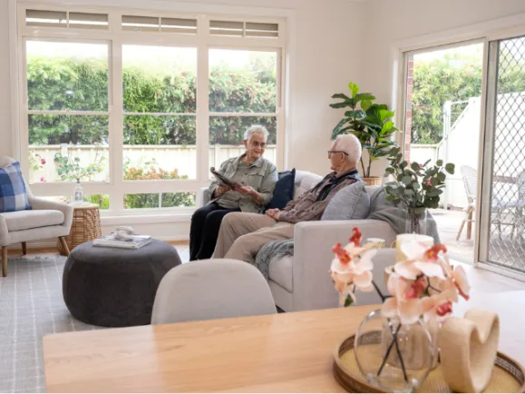 Male & Female Resident In Their Lounge Room At Bedford Heights Estate Retirement Living