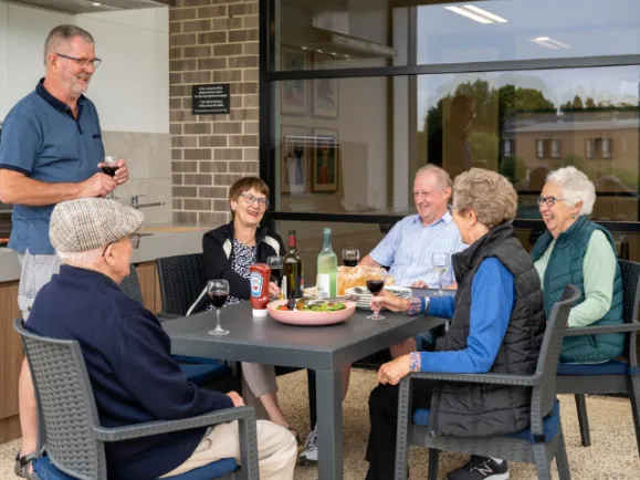 Residents Enjoying Lunch Outside Together At Oakfield Rise Retirement Estate