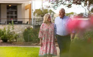 Female and Male Resident Walking Through Garden At The Pines Retirement Living